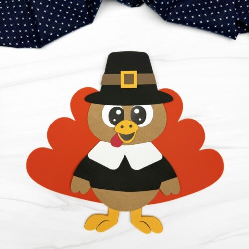 A completed craft of a paper pilgrim turkey with feathers.