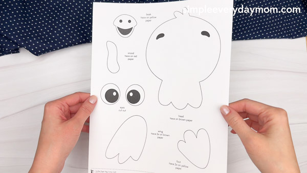 Hands holding a turkey craft template with various cutouts for a blog post.
