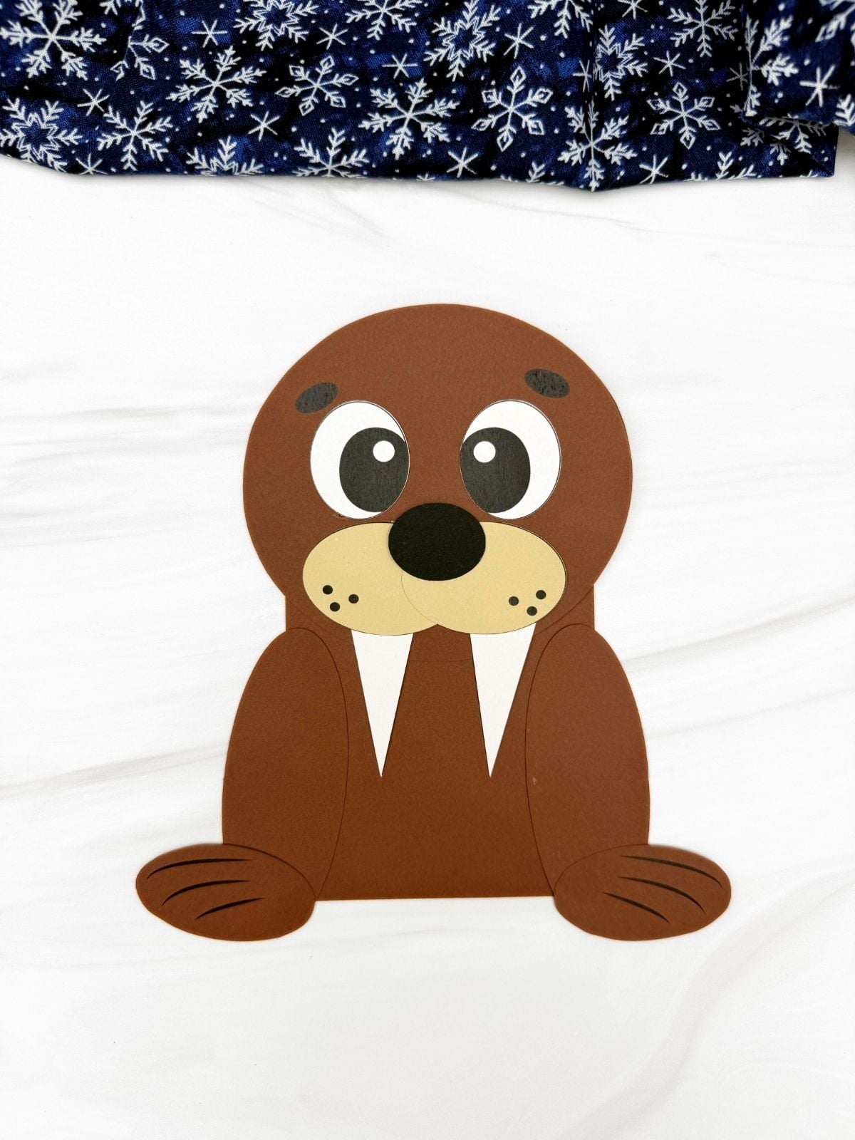 A completed craft showing a brown walrus shape paper craft with tusks and flippers for a kids walrus shape craft activity.