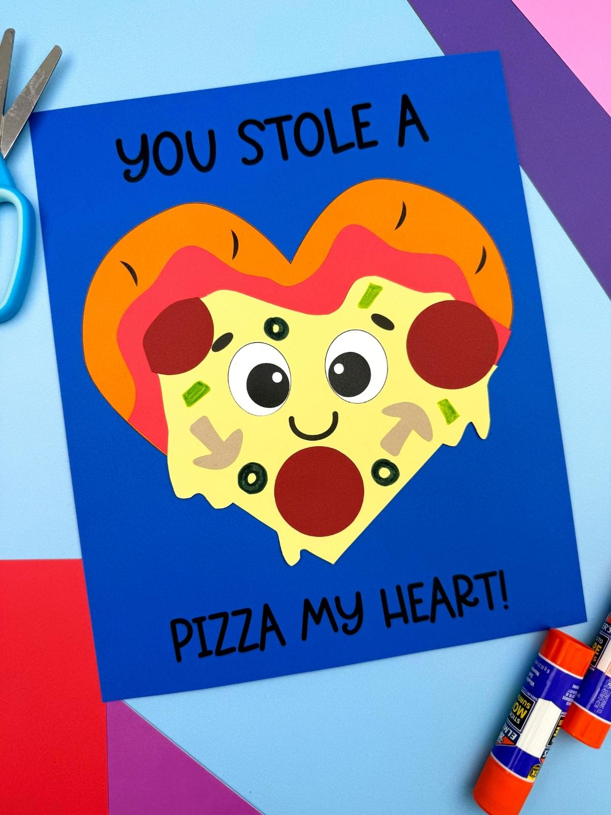 A completed craft Valentine pizza card with a heart shaped slice and “You stole a pizza my heart” message, perfect for a kids Valentine’s Day activity.