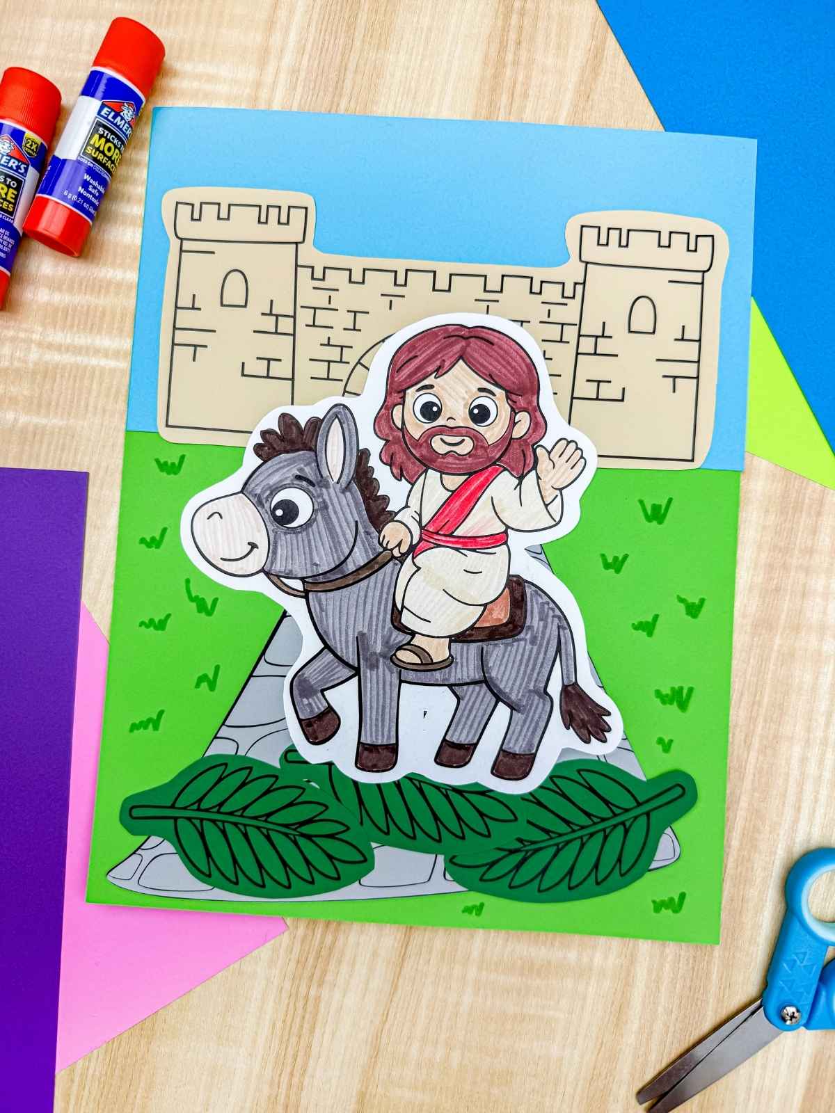 A completed craft of Palm Sunday paper art featuring Jesus riding a donkey, easy preschool and kindergarten Sunday school cut and paste activity with printable template.