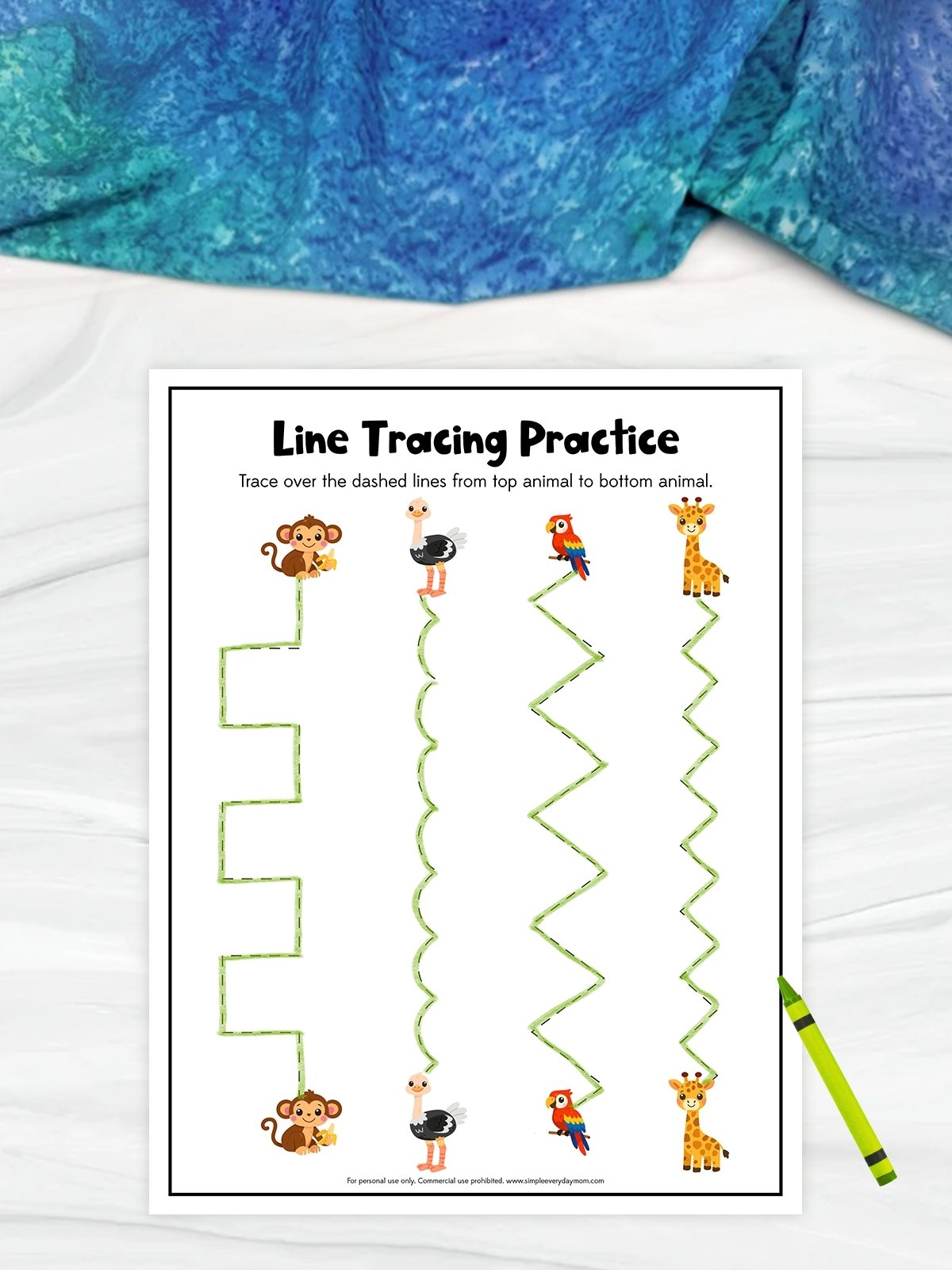 The image shows a children’s line tracing worksheet with a safari animal theme on a light background with blue fabric above. At the top are animals like a monkey, ostrich, parrot, and giraffe, each connected to a matching animal at the bottom by different zigzag or curved dashed lines. The activity encourages kids to trace each path from top to bottom to practice control and coordination.