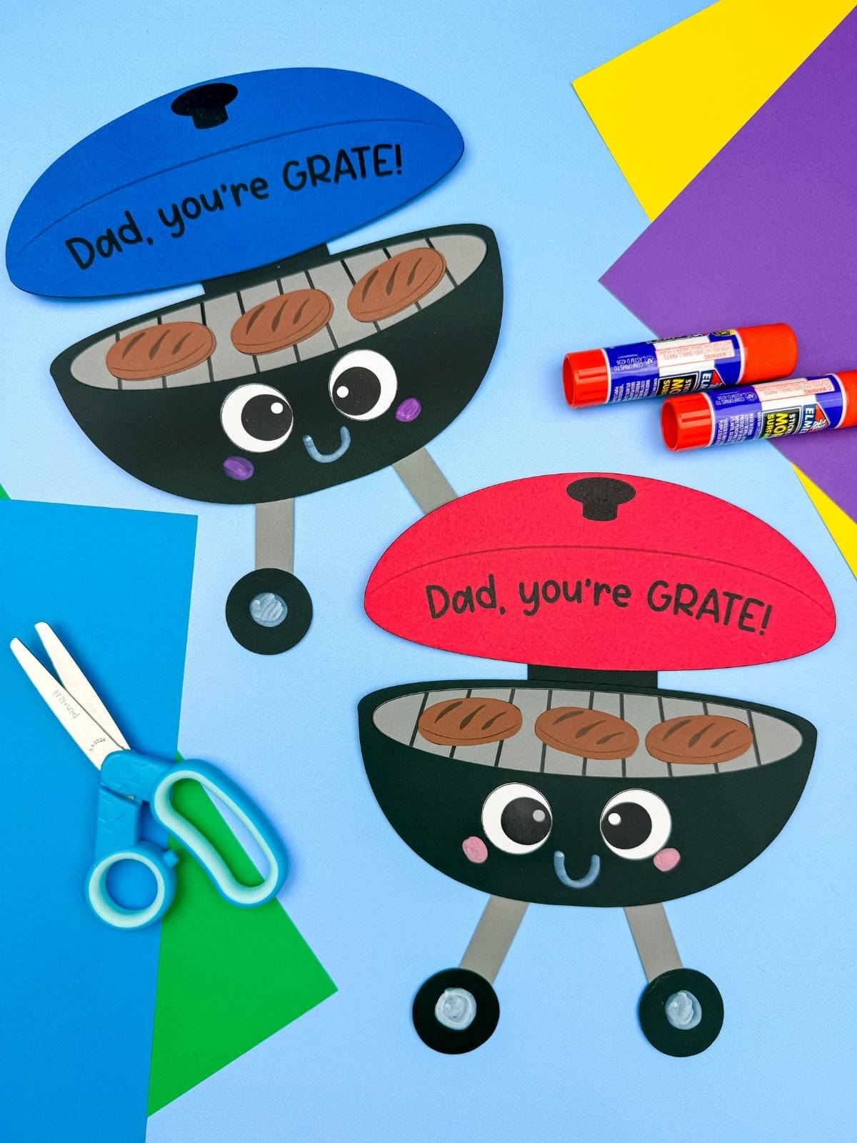 A completed craft showing two Father’s Day grill crafts with blue and red lids and Dad you’re GRATE message with scissors and glue nearby