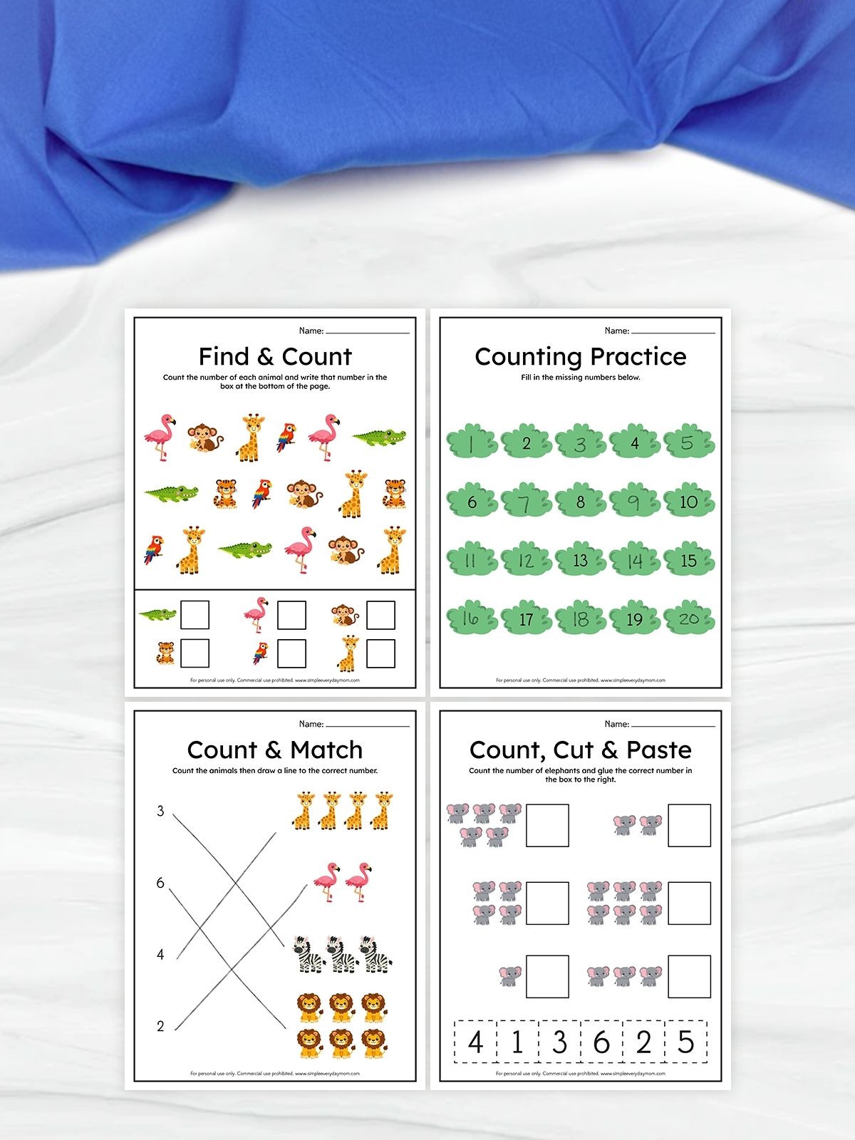 The image shows four children’s counting worksheets arranged in a grid on a light surface with a blue fabric background. The activities include finding and counting animals, filling in missing numbers, matching quantities to numbers, and a cut-and-paste counting exercise. The worksheets use cute animal illustrations to make learning numbers fun and engaging for young kids.