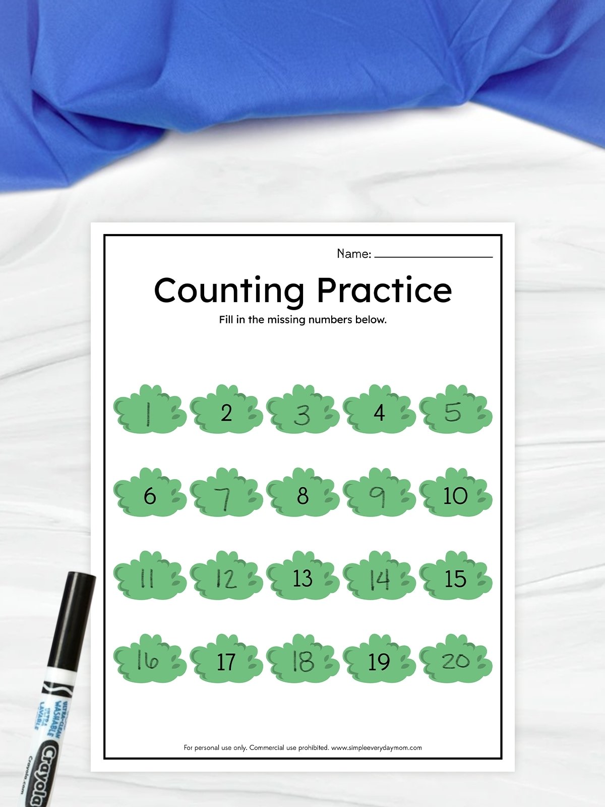 The image shows a children’s worksheet titled “Counting Practice” designed to help kids learn numbers. It displays numbers from 1 to 20 inside green shapes, with some numbers filled in and others left for the child to complete. A marker is placed beside the worksheet, suggesting it is meant to be written on during the activity.