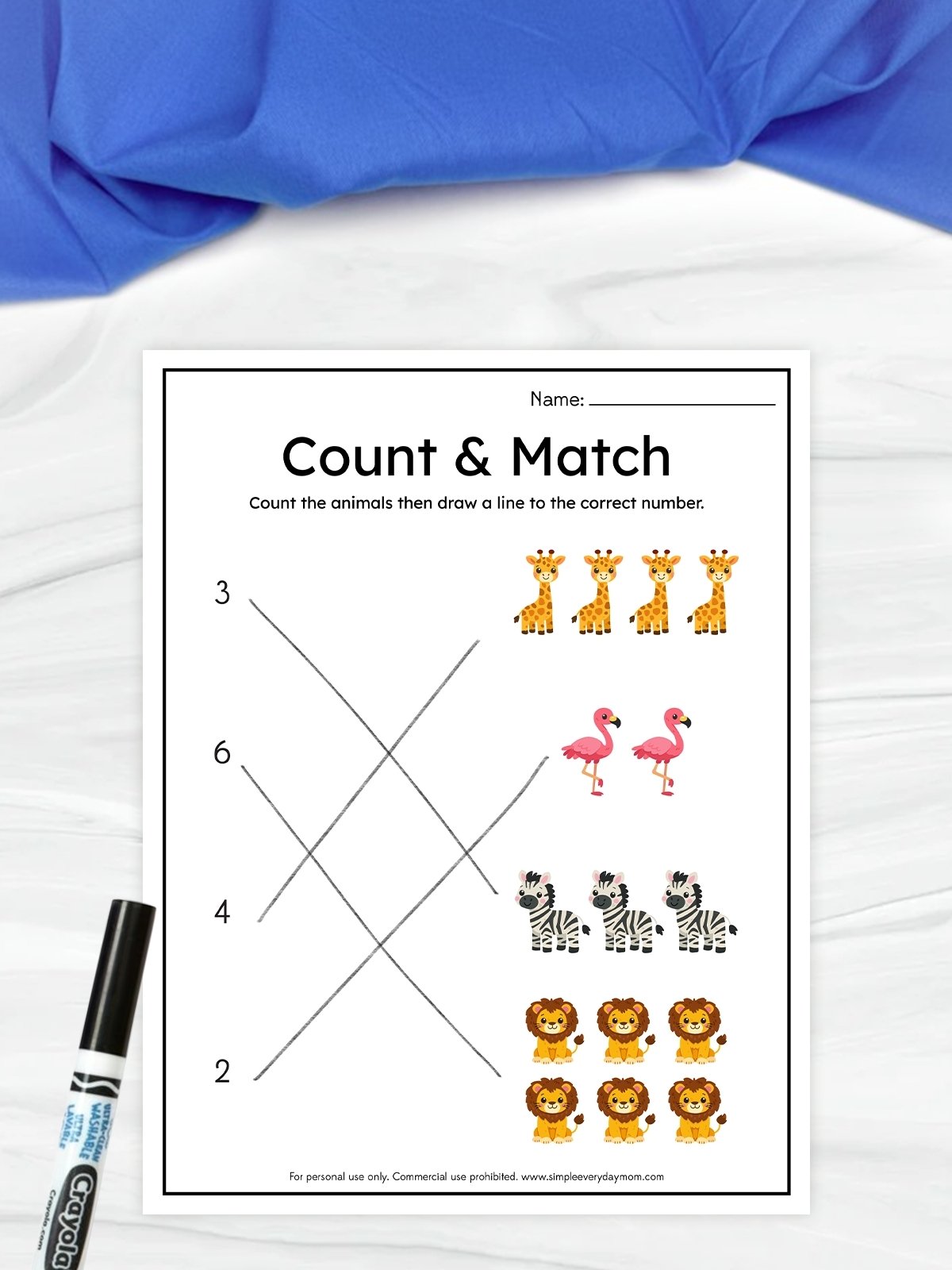 The image shows a children’s worksheet titled “Count & Match,” where kids count animals and connect them to the correct numbers. On one side are numbers, and on the other are groups of animals like giraffes, flamingos, zebras, and lions. Lines are drawn across the page to match each group with its corresponding number, and a marker sits beside the worksheet.