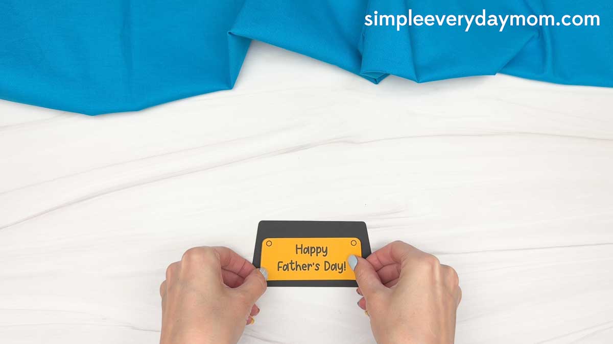 Hands placing the Happy Father’s Day label onto the base of the trophy craft.