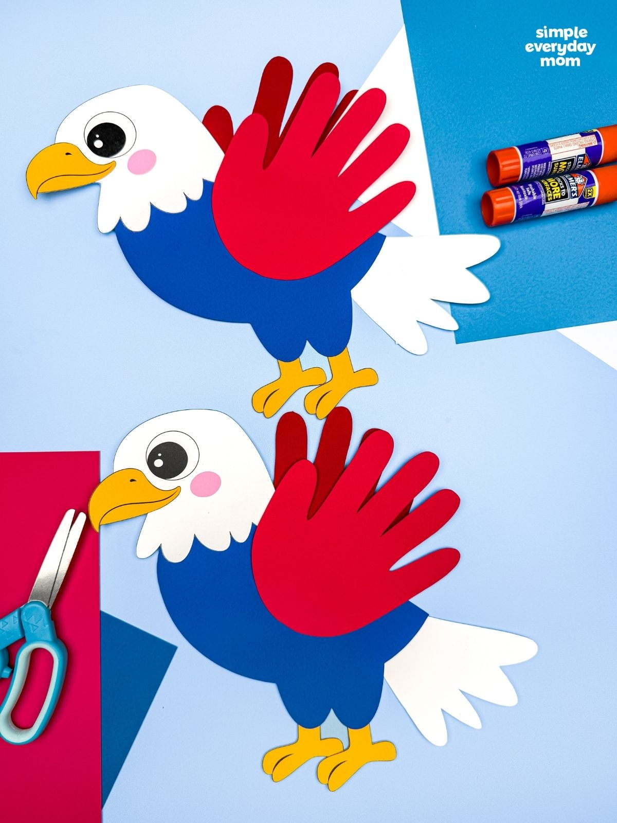 A completed craft showing two American eagle handprint crafts displayed with colorful paper, glue sticks, and scissors.