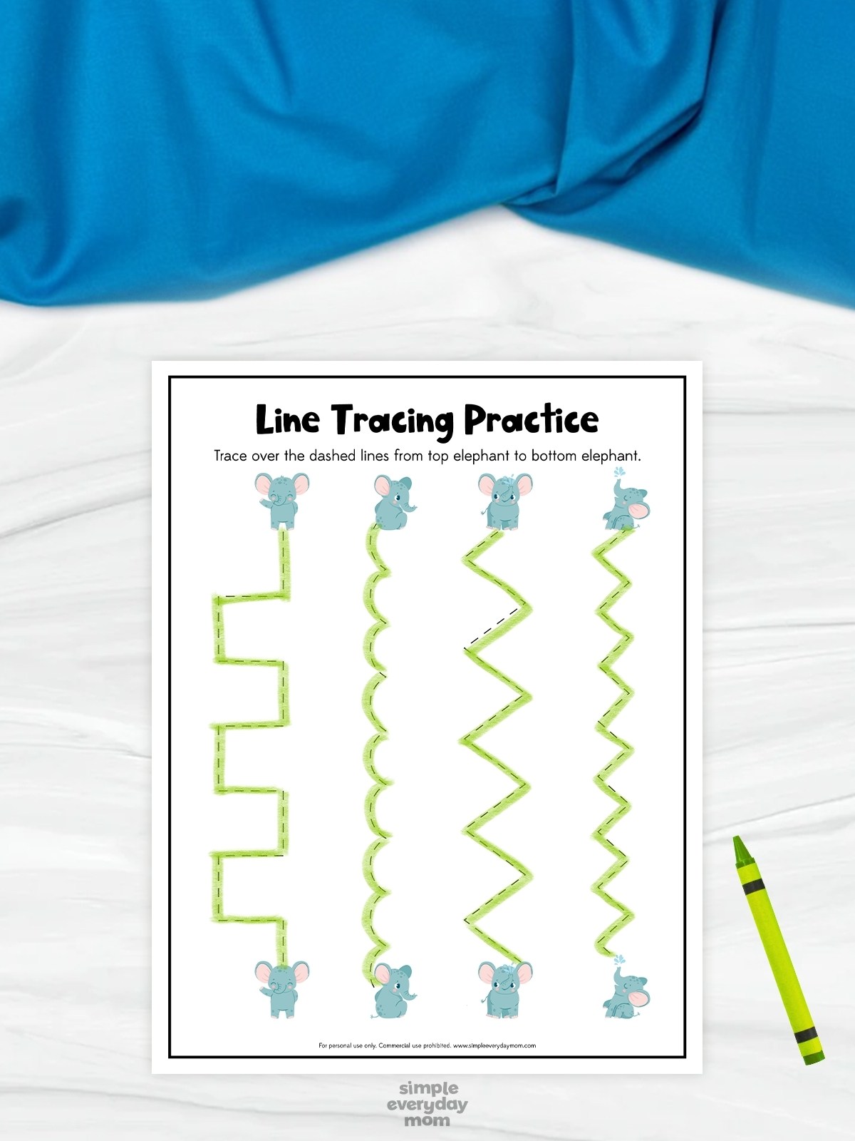 This image shows a printable “Line Tracing Practice” worksheet designed to help preschool children improve fine motor and pre-writing skills. The worksheet features several green tracing paths in different shapes, including straight, curved, and zigzag lines, with cute elephant illustrations at the top and bottom of each path. A bright green crayon beside the worksheet and the playful elephant theme create a fun and engaging learning activity for young children.