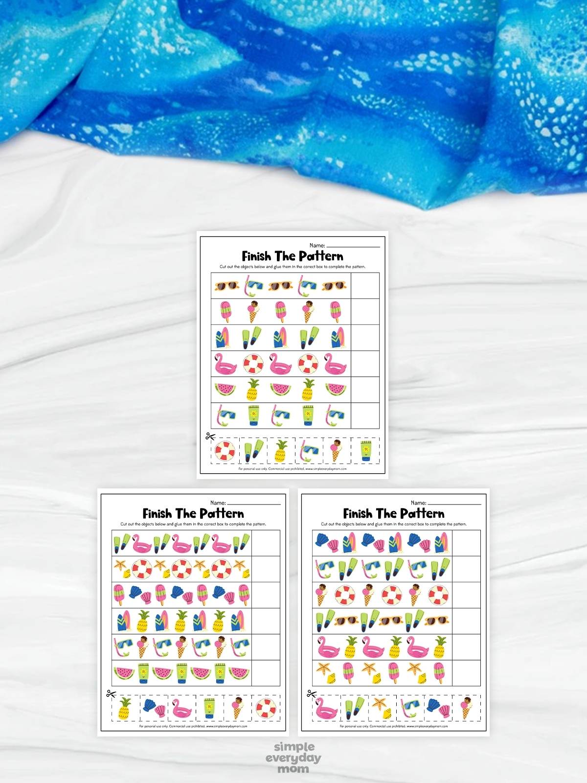 This image shows three printable “Finish The Pattern” worksheets designed to help children practice identifying and completing repeating patterns. The worksheets feature colorful summer-themed pictures such as flamingos, popsicles, pineapples, surfboards, seashells, sunglasses, and beach items arranged in sequences with blank spaces for answers. A bright blue fabric background and cut-and-paste activity pieces give the educational printables a fun, interactive, and kid-friendly appearance for preschool and kindergarten learners.
