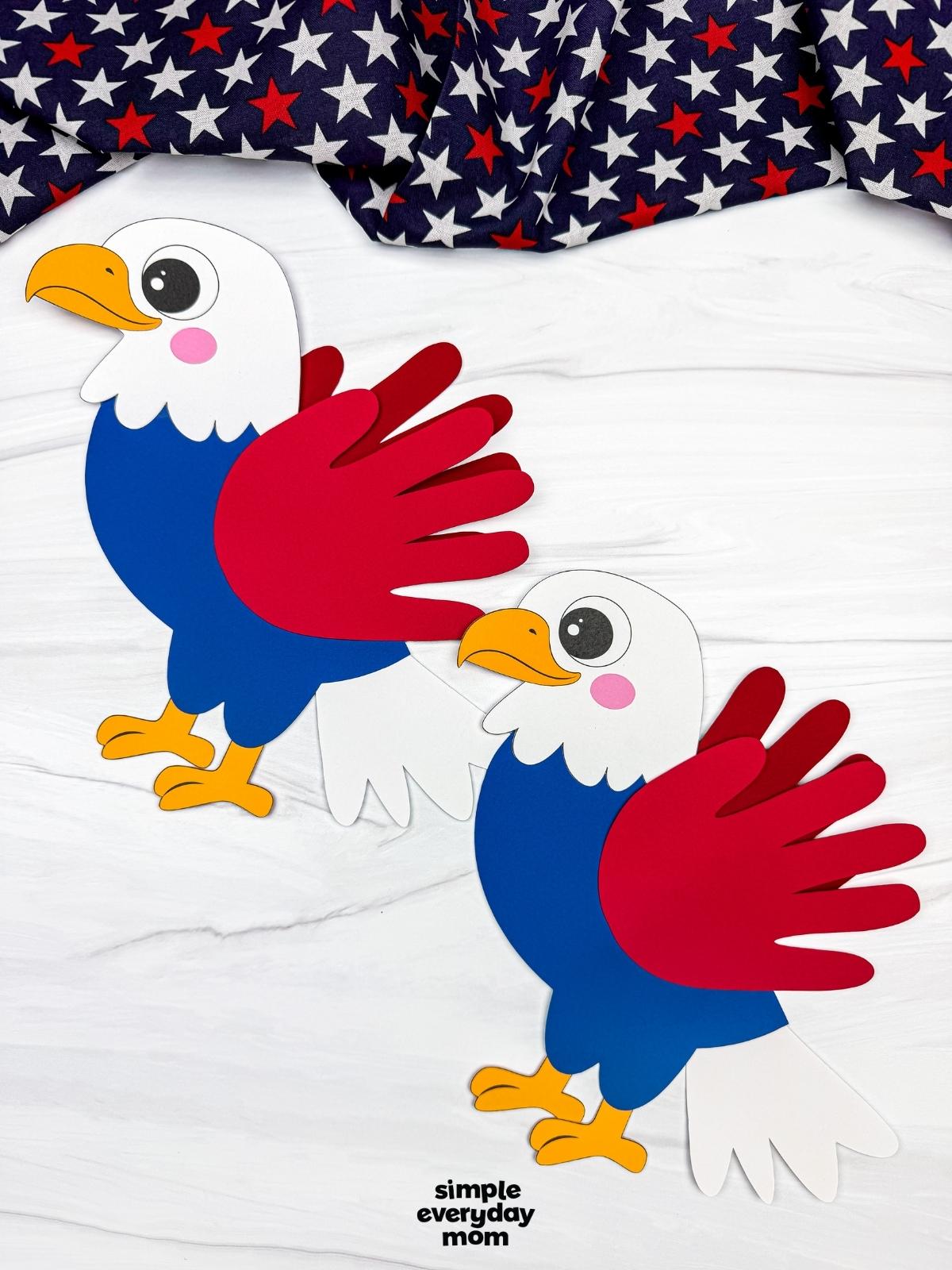 A completed craft showing two American eagle handprint crafts with red wings, blue bodies, and white tail feathers on a patriotic themed background.