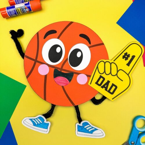 A completed craft of a basketball Father’s Day character with a number one dad foam finger and colorful craft supplies.