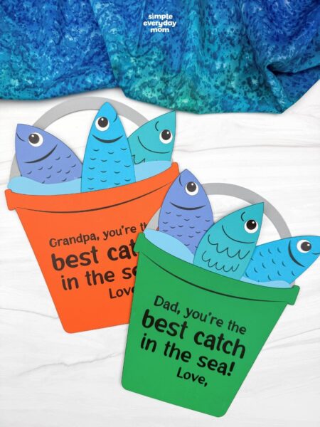 A completed Father’s Day fishing bucket craft with colorful paper fish and best catch in the sea messages for dads and grandpas.