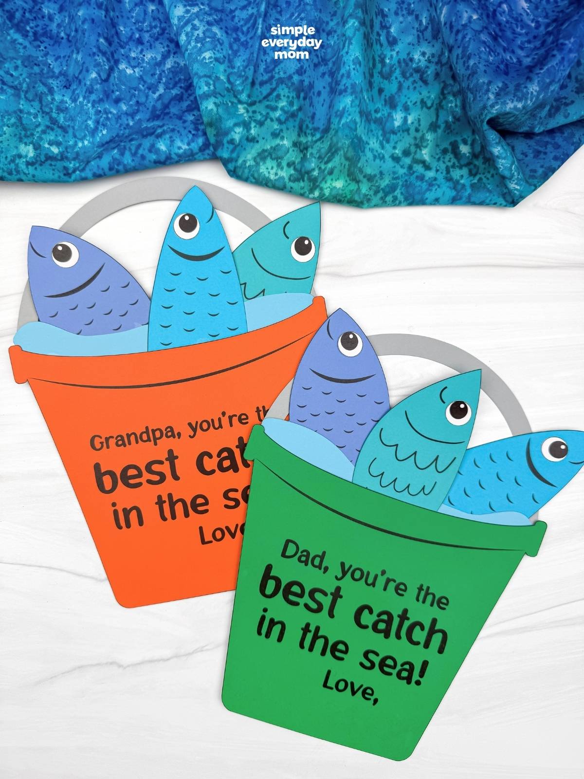 A completed Father’s Day fishing bucket craft with colorful paper fish and best catch in the sea messages for dads and grandpas.