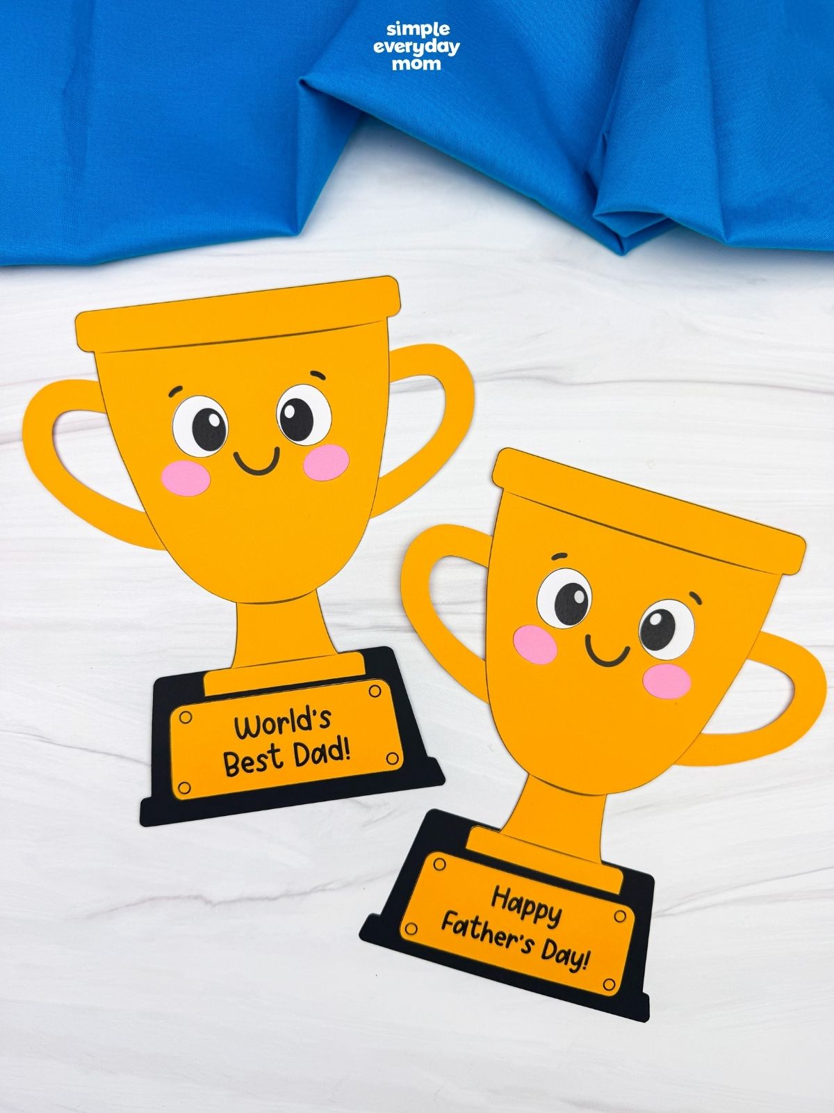 A completed craft showing two smiling Father’s Day trophy crafts with World’s Best Dad and Happy Father’s Day messages.