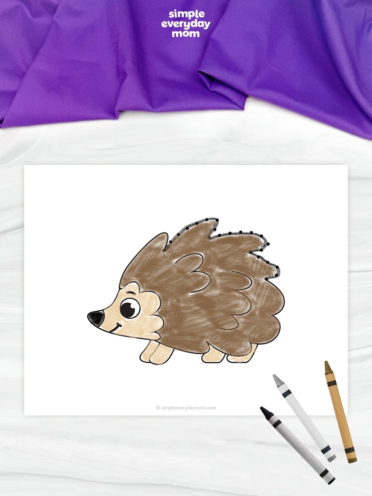 This image features a completed hedgehog connect-the-dots worksheet displayed on a light marble-like background. The hedgehog is colored in shades of brown and cream, with numbered dots tracing the outline of its spines across the top and back. Several crayons are placed in the lower-right corner, while a purple fabric backdrop and the Simple Everyday Mom logo are visible at the top of the image.