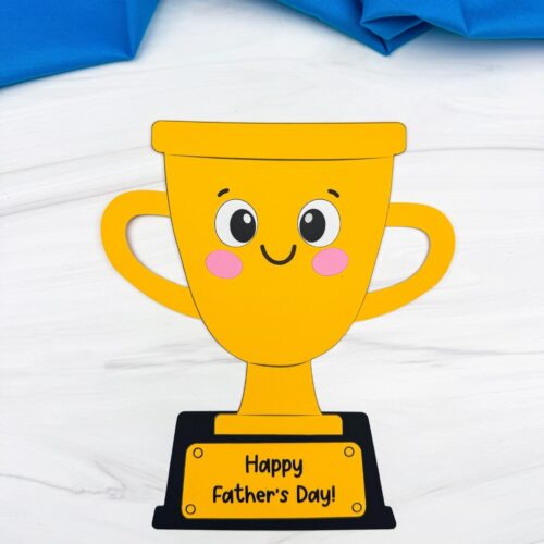 A completed craft showing a smiling Father’s Day trophy craft with a Happy Father’s Day message on the base.