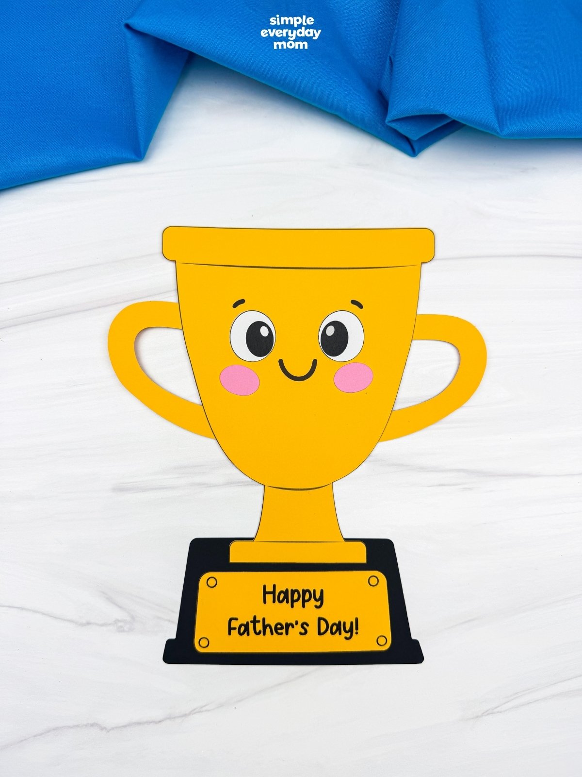 A completed craft showing a smiling Father’s Day trophy craft with a Happy Father’s Day message on the base.