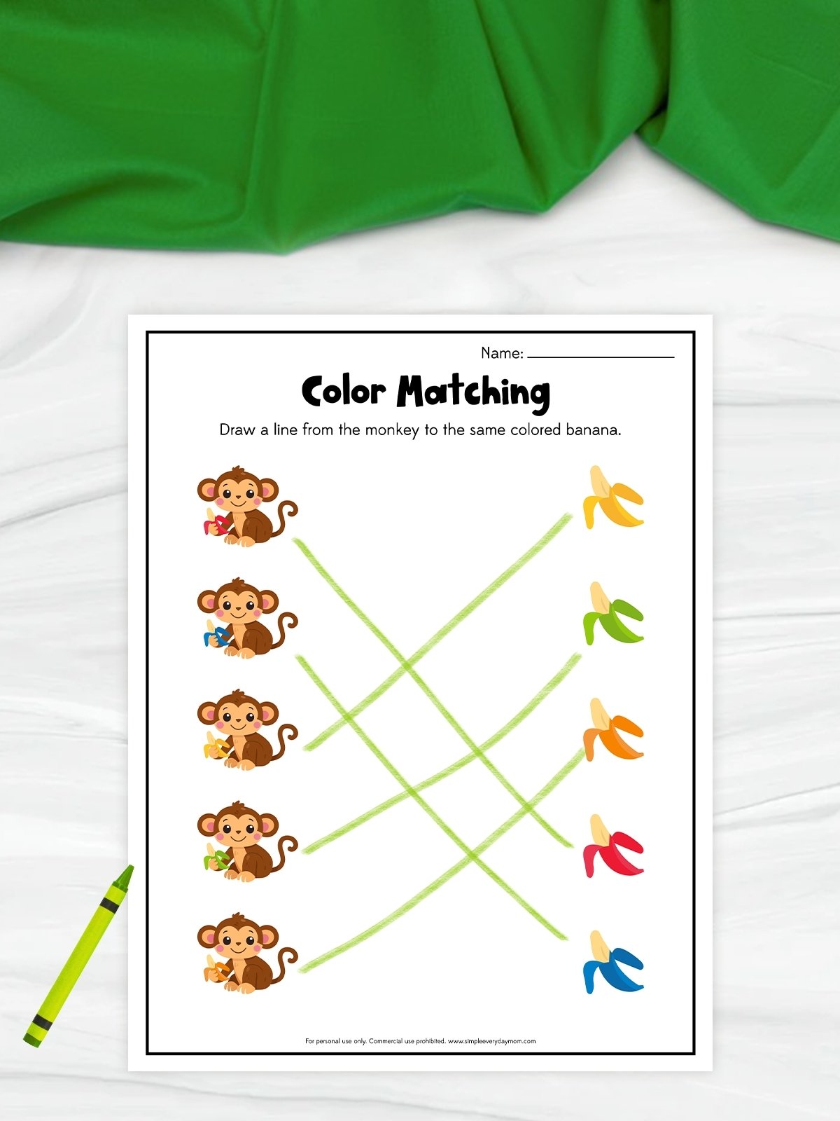 This image shows a printable “Color Matching” worksheet designed to help young children practice color recognition and matching skills. The worksheet features monkeys holding different colored bananas on the left side and matching colored bananas on the right, connected with light green lines. A bright green crayon and cheerful cartoon illustrations give the educational activity page a fun and playful appearance for preschool learners.