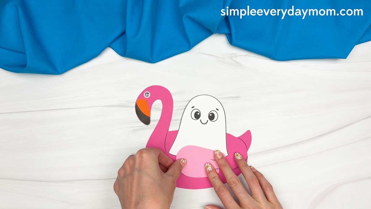 Hands attaching the flamingo wing piece to the Summerween ghost craft.