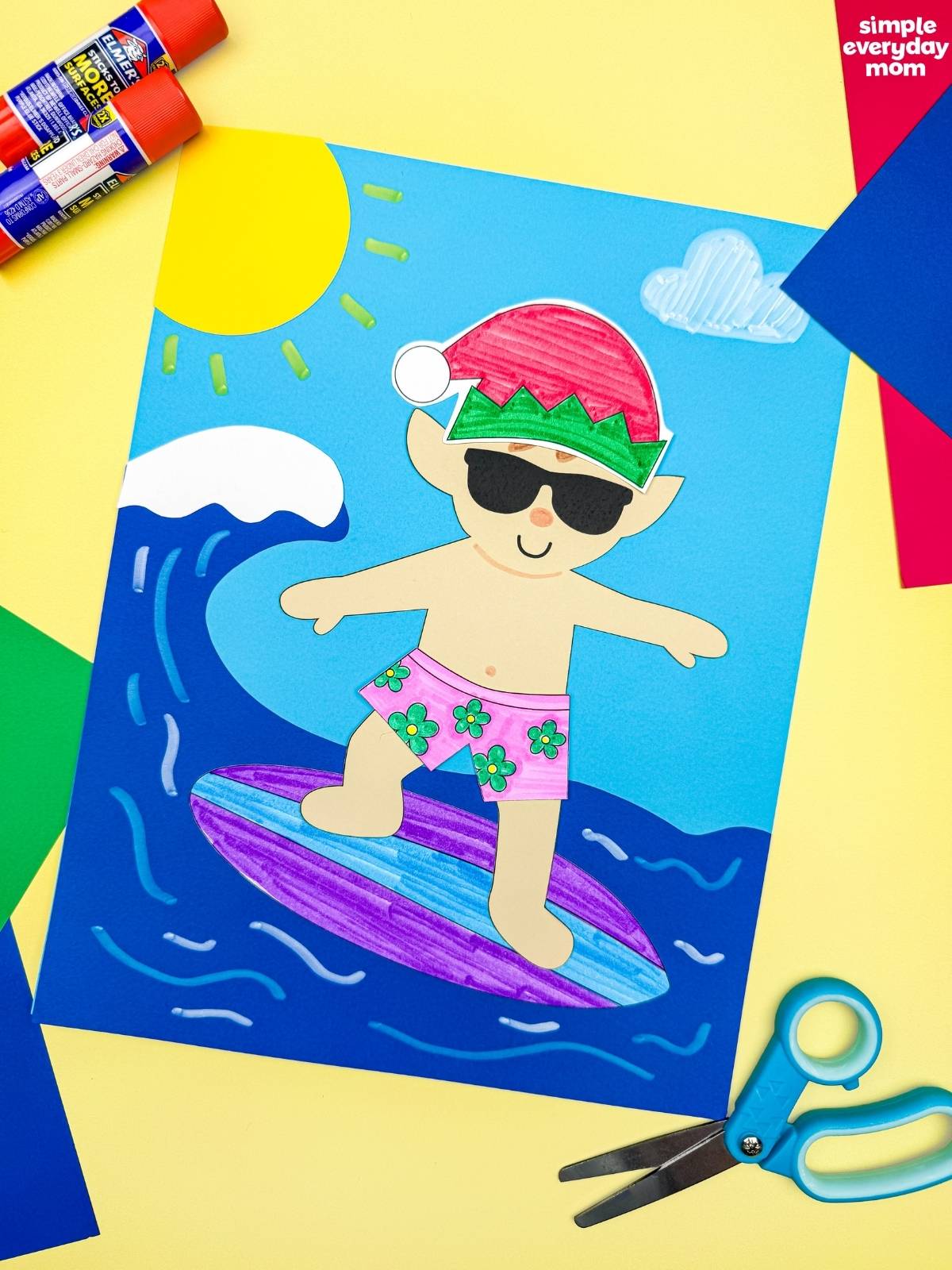 A completed Craft featuring an elf in sunglasses, a Santa hat, and pink floral swim trunks surfing on a colorful board with ocean waves, a bright sun, and a cloud.