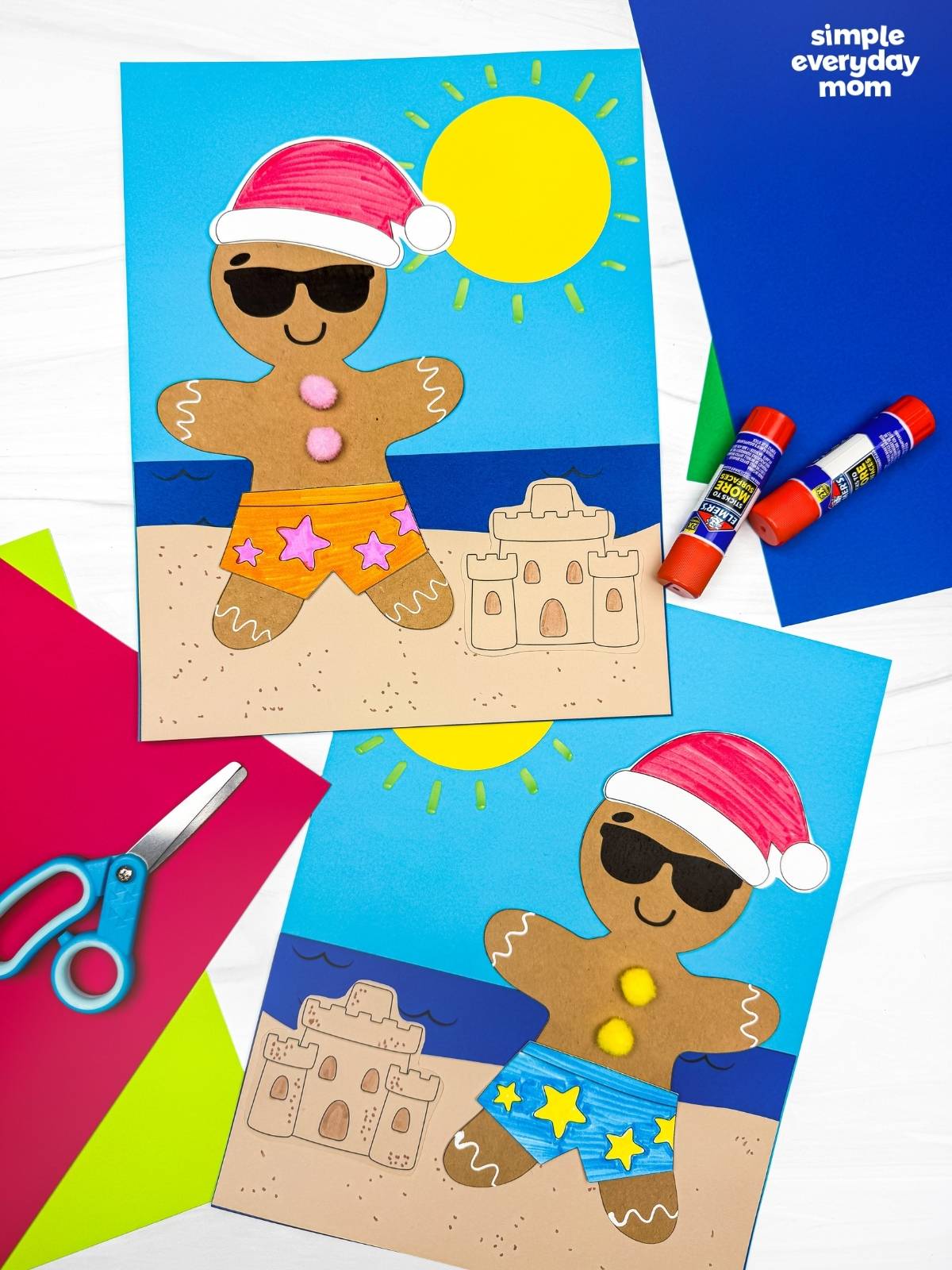 A completed Craft featuring two Christmas in July gingerbread beach crafts with Santa hats, sunglasses, colorful swim shorts, sandcastles, and craft supplies arranged around them.