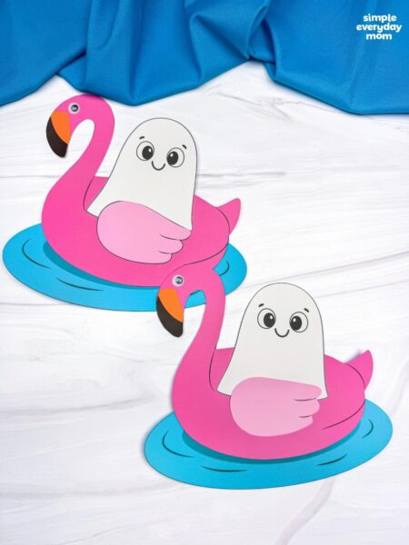 A completed craft showing two Summerween ghosts floating in pink flamingo pool floats.