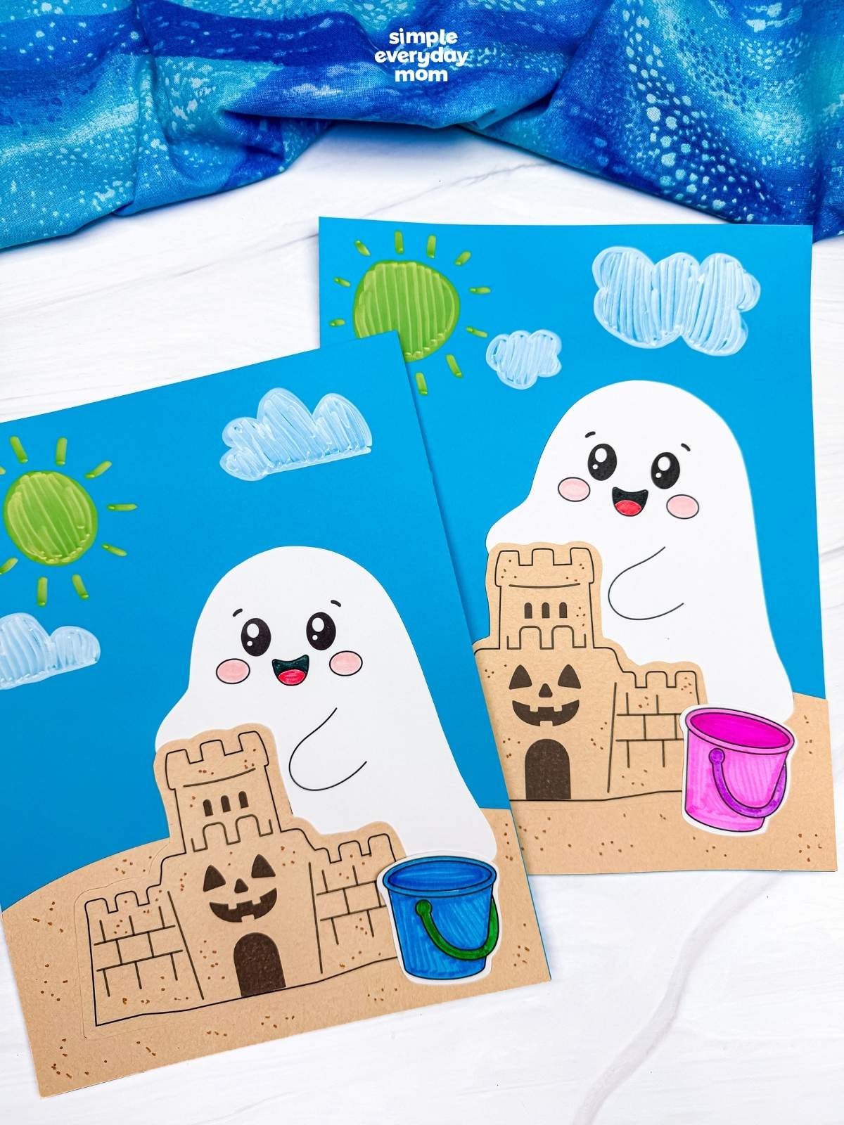 A completed Craft featuring two beach ghost scenes with smiling ghosts, sandcastles, colorful beach buckets, and sunny skies with fluffy clouds.
