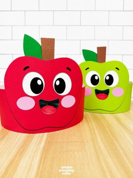 A completed craft showing red and green apple headband crafts displayed together for a fun fall classroom activity.