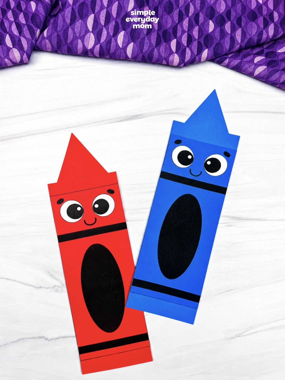 A completed red and blue crayon shape crafts with smiling faces displayed side by side.
