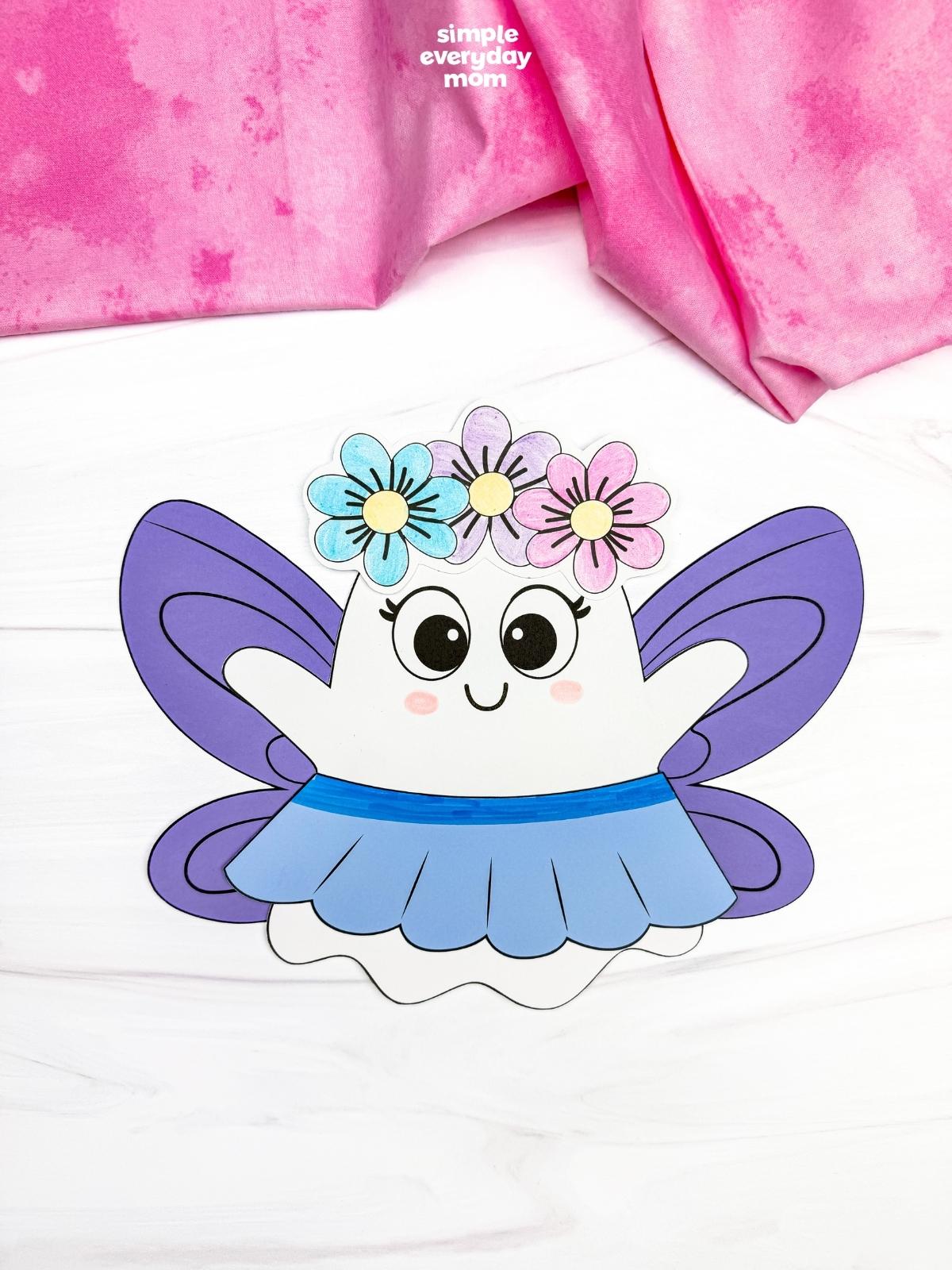 A completed craft of the Fairy Ghost Disguise Craft with purple fairy wings, a flower crown, and a blue skirt.
