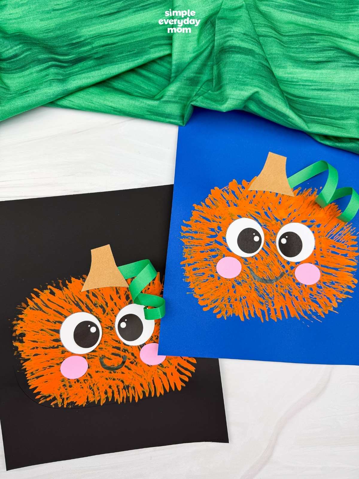 Side by side completed Fork Painted Pumpkin Craft examples displayed on black and blue paper backgrounds.