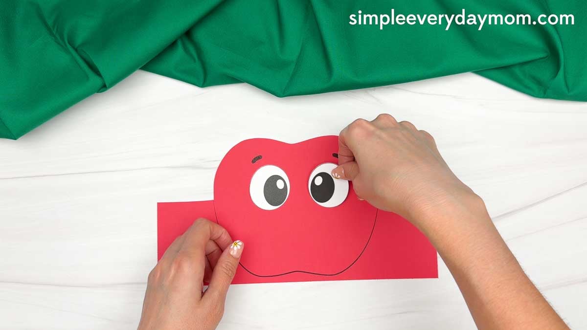 Hands gluing the eye pieces onto the apple headband template.