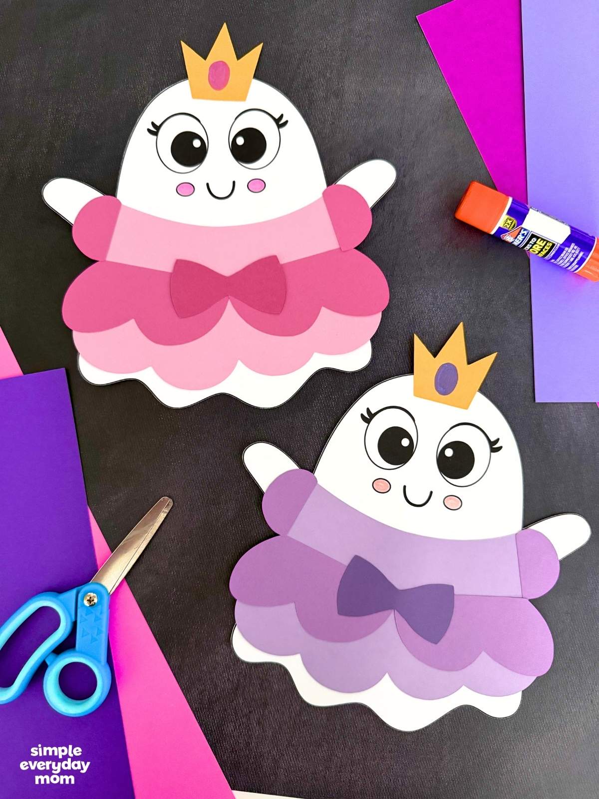 A completed craft showing two finished Princess Ghost Disguise Craft designs displayed with colorful paper, scissors, and a glue stick.