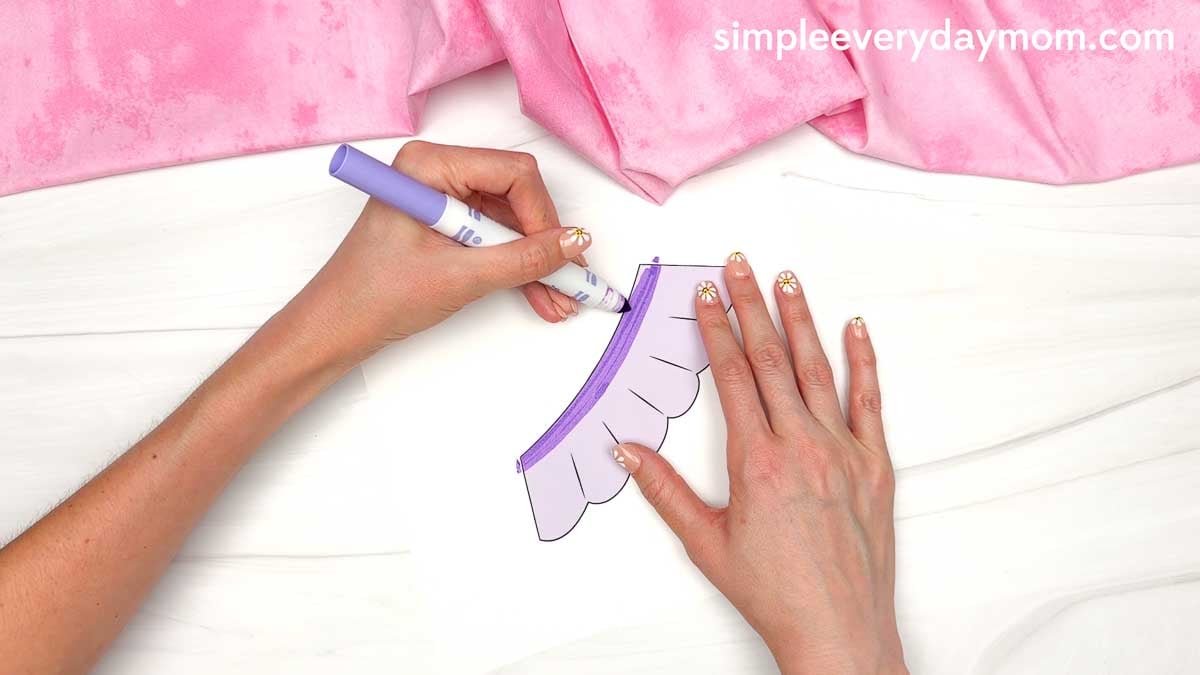 Hands coloring the trim on the Fairy Ghost Disguise Craft skirt template with a marker.