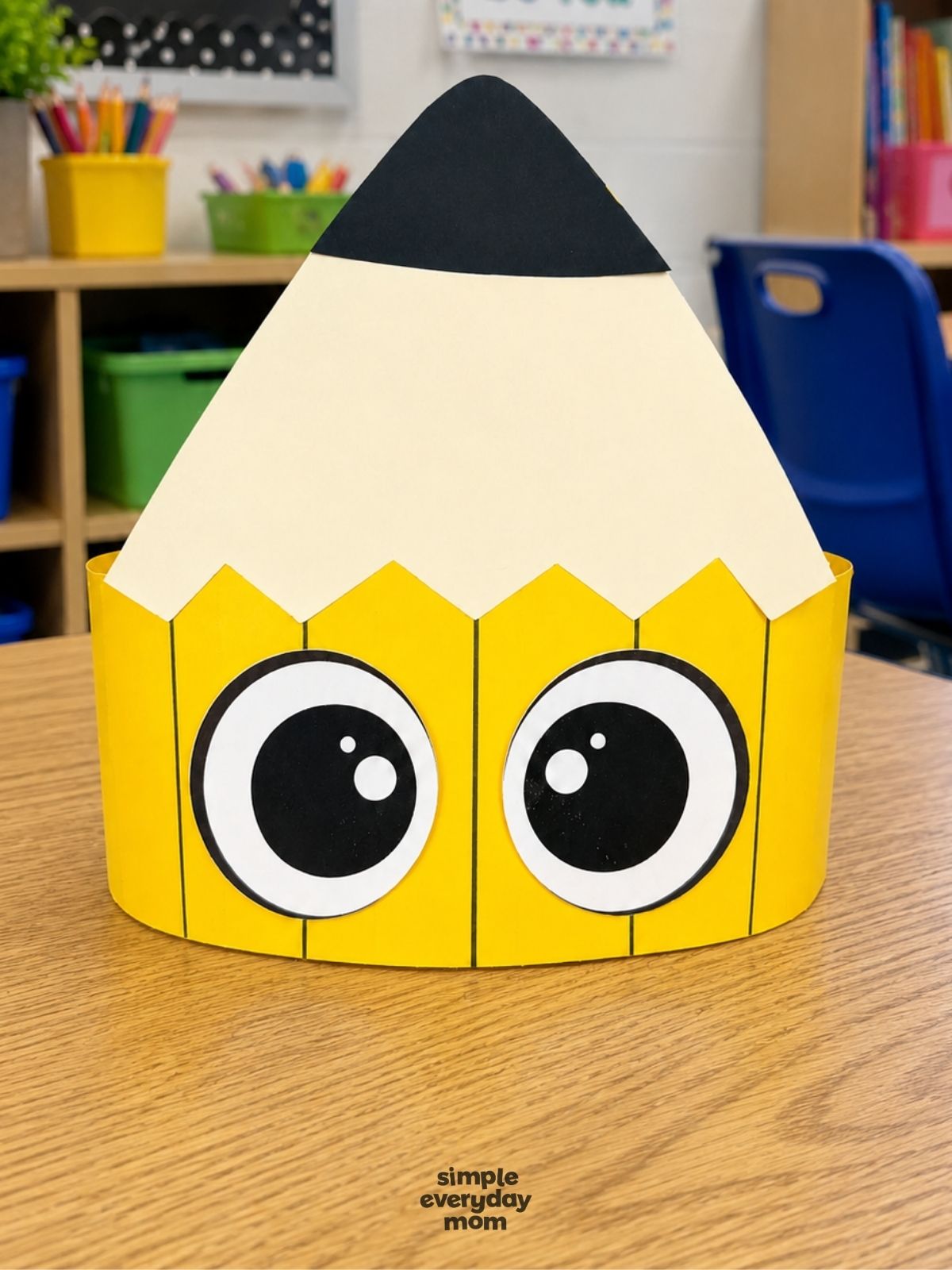 A completed craft of a printable pencil headband displayed on a classroom table.