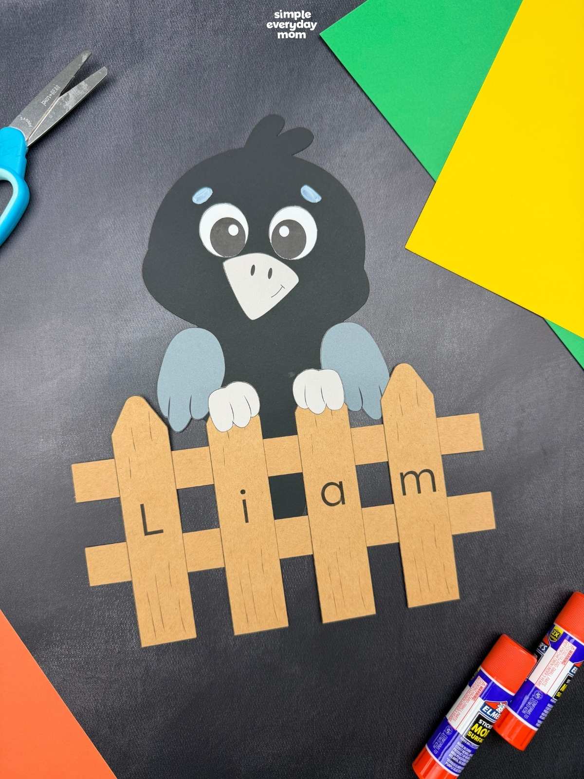 A completed Craft showing a crow perched behind a personalized name fence spelling Liam.