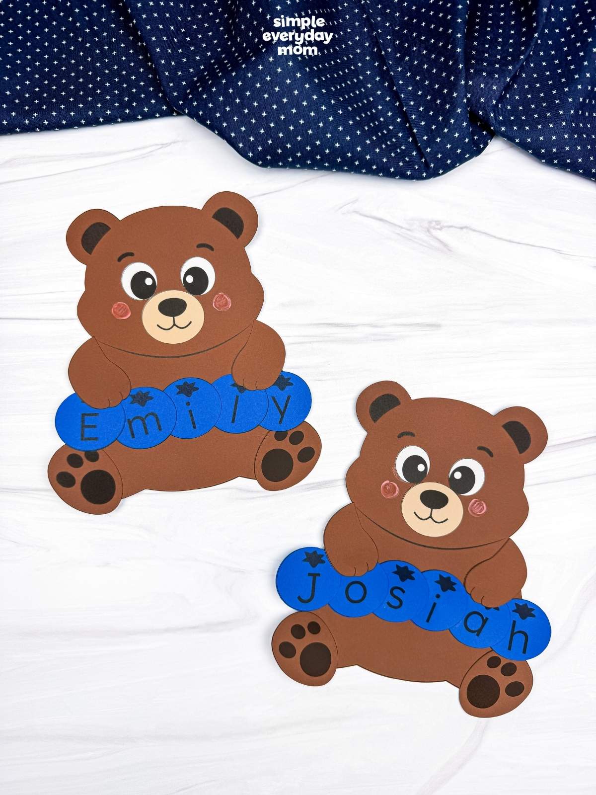 A completed Craft featuring two brown bears holding blue letter pieces spelling Emily and Josiah.
