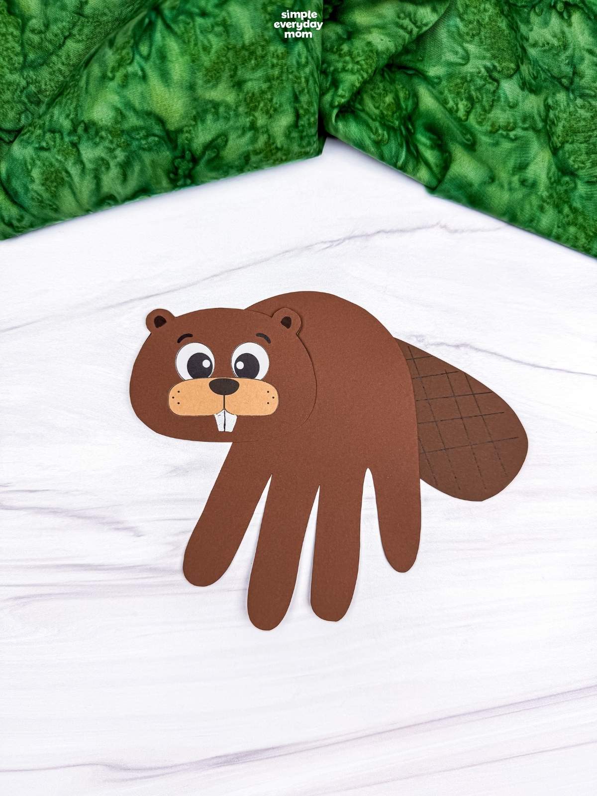 A completed Beaver Handprint Craft with a paper handprint body, beaver face, and textured tail.