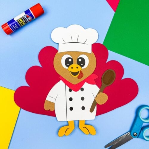 A completed Craft featuring a chef turkey disguise with red tail feathers, a white chef uniform, and a brown spoon.