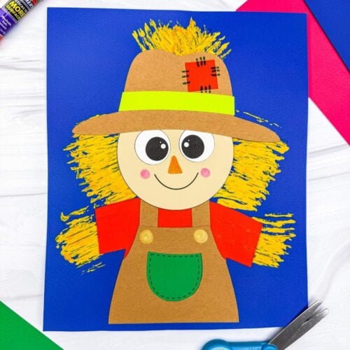 A completed craft of a Fork Painted Scarecrow Craft with a painted straw background displayed on a sheet of paper.