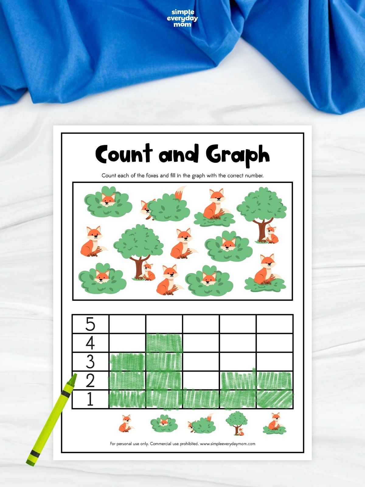 A fox count and graph worksheet with colorful foxes, bushes, and trees to count. Children count each type of picture and fill in the graph to show the correct totals. A green crayon rests beside the completed graphing activity.