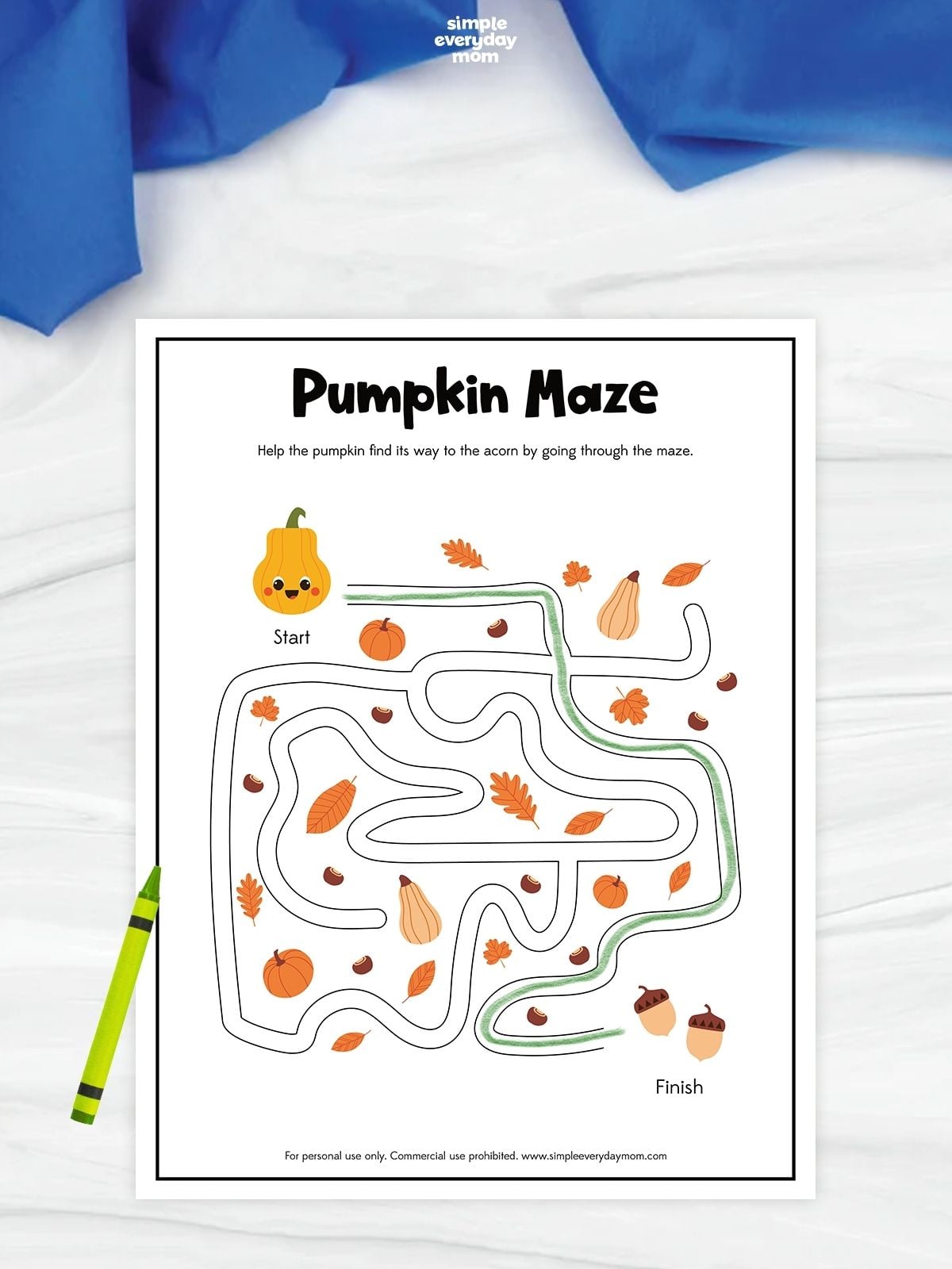 Pumpkin maze worksheet with a green path traced from a smiling pumpkin at the start to two acorns at the finish, surrounded by autumn leaves, pumpkins, gourds, and acorns.