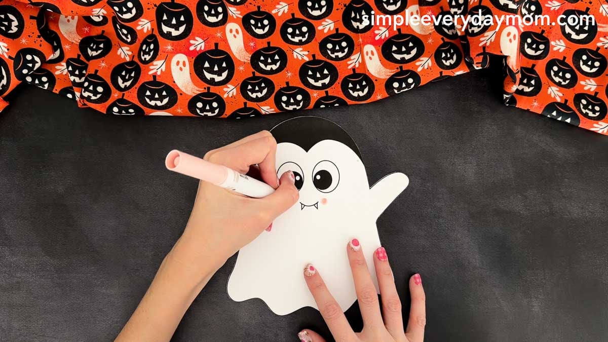 Hands drawing the left eye detail on the ghost template before assembling the Vampire Ghost Disguise Craft.
