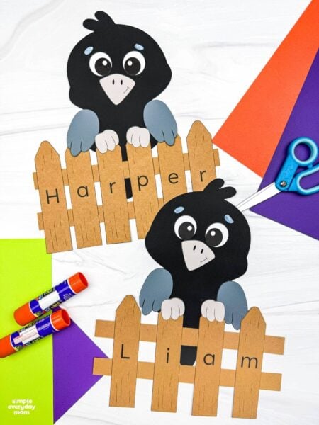 A completed Craft showing two crows behind personalized name fences spelling Harper and Liam.