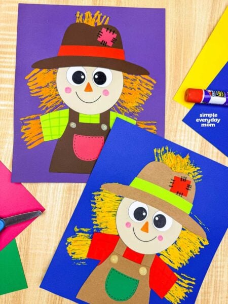 Side by side completed Fork Painted Scarecrow Craft examples with painted straw backgrounds displayed on colorful sheets of paper.