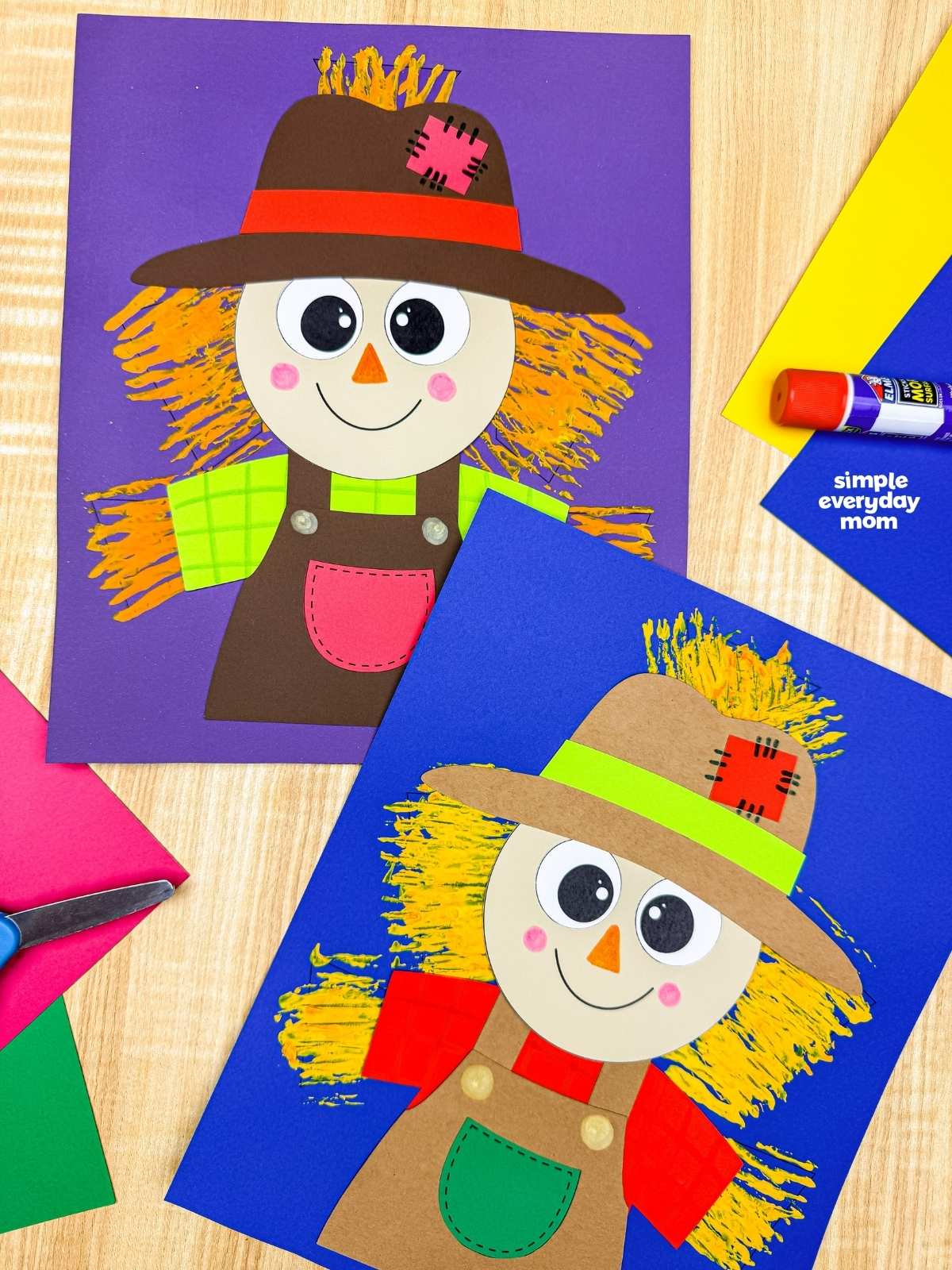 Side by side completed Fork Painted Scarecrow Craft examples with painted straw backgrounds displayed on colorful sheets of paper.