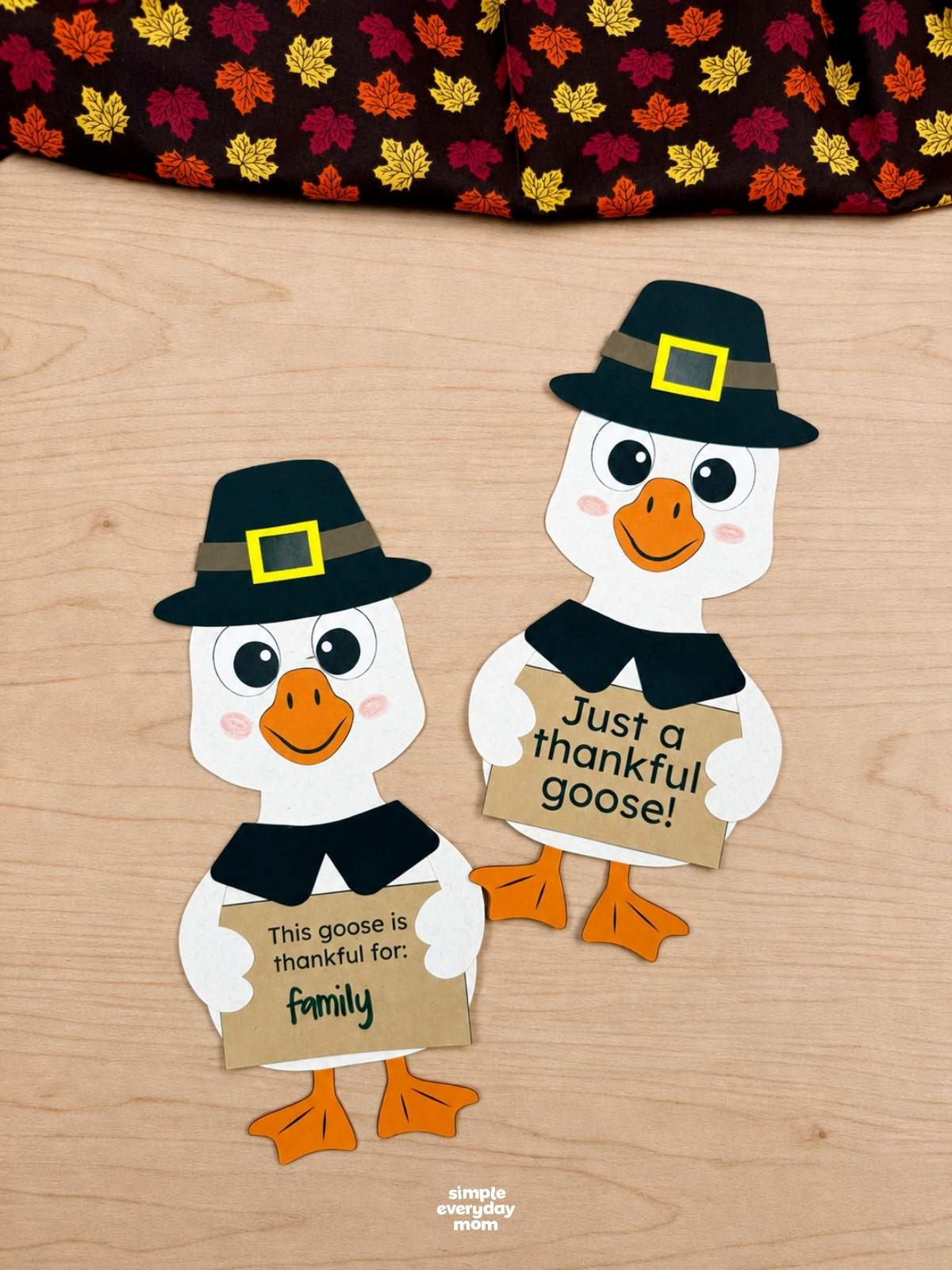 A completed craft featuring two thankful geese wearing pilgrim hats and holding Thanksgiving gratitude signs.