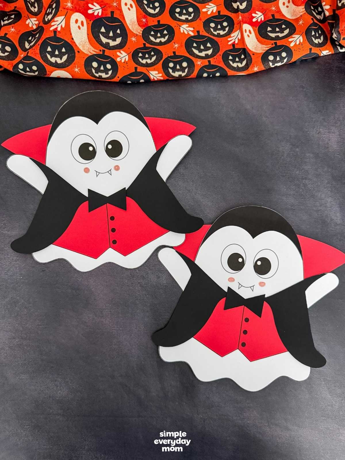 A completed craft of two Vampire Ghost Disguise Crafts displayed side by side wearing capes, collars, bow ties, and vests.