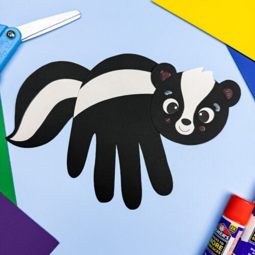 A completed Craft featuring a black handprint skunk with white stripes surrounded by colorful craft supplies.